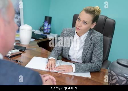 Frau, die mit dem Kunden eine Kfz-Versicherung unterzeichnet Stockfoto