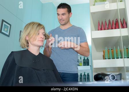 Friseur während der Arbeit mit Frau Stockfoto