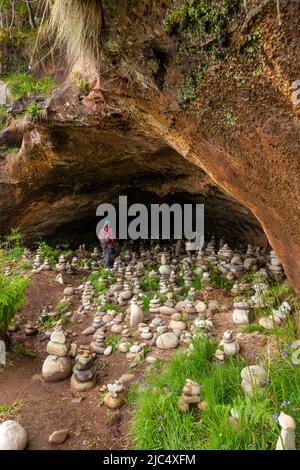 Eine Person in einer kleinen Höhle, Drumadoon in der Nähe von Blackwaterfoot, Isle of Arran, Schottland Stockfoto