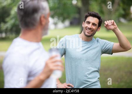 Männer, die sich nach dem Joggen im Park strecken Stockfoto