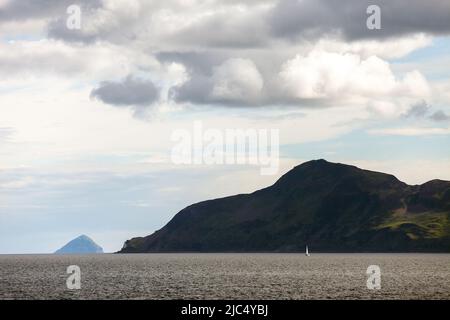 Mit Ailsa Craig von der Fähre aus, die den Hafen von Brodick auf der Insel Arran verlässt, blickt man auf die Heilige Insel.Ihr höchster Punkt ist der Hügel Mullach Mòr Stockfoto