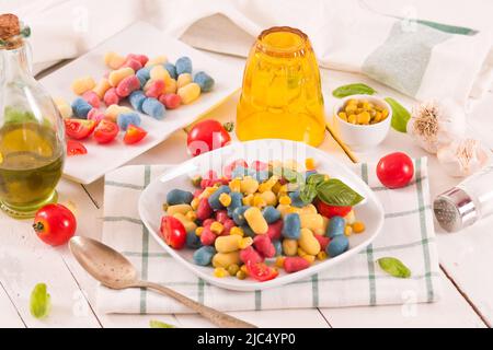 Farbige Gnocchi mit Gemüse und süßem Mais. Stockfoto