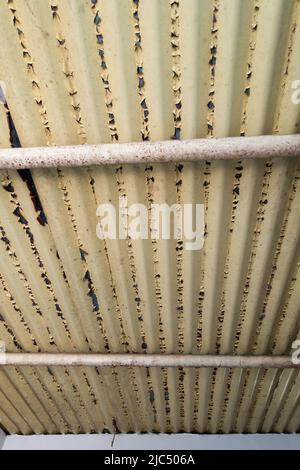 Eine Nahaufnahme der Farbe, die in geschälter Form von einem Blechdach abstammt. uttarakhand Nordindien. Stockfoto