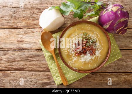 Cremig pürierte Kohlrabi-Suppe mit Speck und Parmesan in einer Schüssel auf dem Tisch. Horizontale Draufsicht von oben Stockfoto