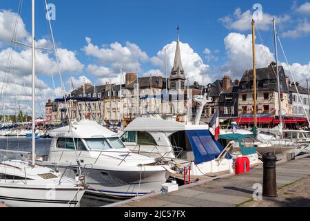 HONFLEUR, FRANKREICH - 1. SEPTEMBER 2019: Blick auf den Pier im Alten Hafen und die mittelalterliche Kirche Saint Etienne (14.. Jahrhundert). Stockfoto