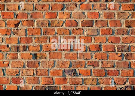 Roter Backsteinwand, eine wunderschöne architektonische Struktur einer alten Klinkerwand eines historischen Gebäudes Stockfoto