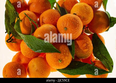 Glasvase mit Mandarinen. Einrichtung für Neujahr und Weihnachten. Mandarinen in einer Glasvase auf einem Tisch Stockfoto