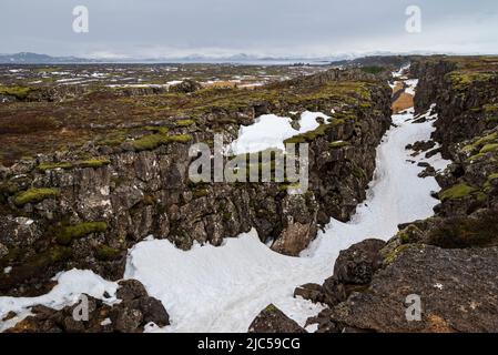 Erhöhter Blick auf die schneebedeckte Almannagjá-Schlucht im Spätwinter, Thingvellir / Þingvellir Nationalpark, Golden Circle Route, Island Stockfoto