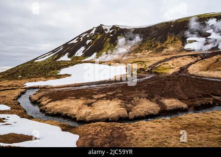 Dampf steigt über den heißen Quellen im Reykjadalur-Tal, Ziel eines beliebten Wanderweges, Reykjadalsá-Fluss im Vordergrund, Hengill, Island Stockfoto