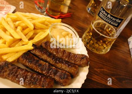 Rumänisches Abendessen mit Bier und Mititei in Timisoara Stockfoto