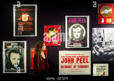 London, Großbritannien. 10. Juni 2022. Ein Mitarbeiter sieht Poster bei der Vorschau von „Live in Session: Property from the John Peel Archive“ in Bonhams Knightsbridge. Am 14. Juni werden Artikel aus der Musiksammlung des verstorbenen John Peel, des verstorbenen BBC Radio DJ, Journalisten und Senders, zum Verkauf angeboten. Kredit: Stephen Chung / Alamy Live Nachrichten Stockfoto