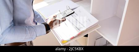 Nahaufnahme der Hand, denn ein Geschäftsmann Foto von Bill mit Handy Stockfoto