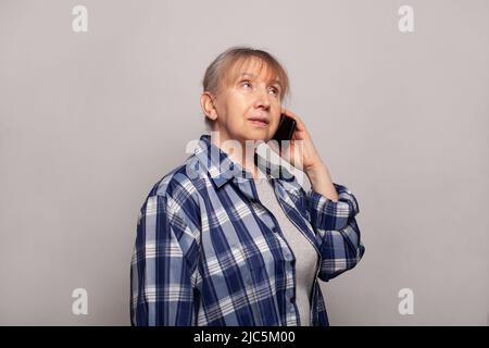 Lächelnde ältere Frau, die auf dem Mobiltelefon spricht Stockfoto