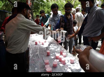 Neu-Delhi, Indien. 10.. Juni 2022. Die Menschen verteilen Süßwasser an Pendler, während sie ihren Durst an einem heißen Nachmittag in Neu-Delhi, Indien, am 10. Juni 2022 stillen. Quelle: Partha Sarkar/Xinhua/Alamy Live News Stockfoto