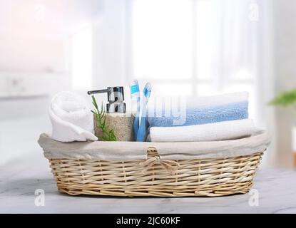 Morgenhygiene.Zahnbürsten, Handtücher und Seife im Korb auf dem Tisch im Badezimmer.Wäsche. Stockfoto
