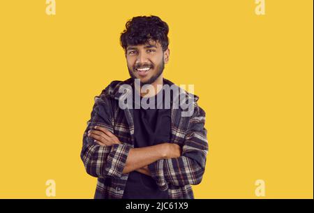 Porträt eines attraktiven positiven indischen oder arabischen Mannes auf orangefarbenem Hintergrund. Stockfoto