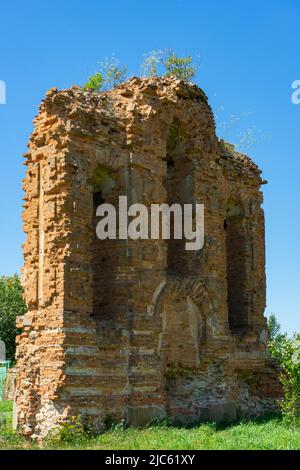 Die Mauer einer alten christlichen Kirche. Überreste eines zerstörten Tempels aus rotem Backstein. Stockfoto