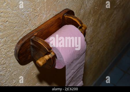 Toilettenpapierrolle auf einem hölzernen Kleiderbügel Stockfoto