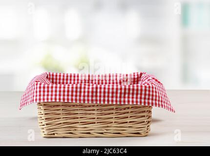 Leerer Strohkorb mit rot kariertem Picknick-Tuch leerer Raum Lebensmittel Werbung Design, Container. Stockfoto