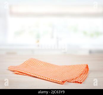 Orange Serviette, gefaltetes Küchentuch, Picknick-Tuch auf Holztisch leeren Raum Hintergrund. Tischplatte. Stockfoto