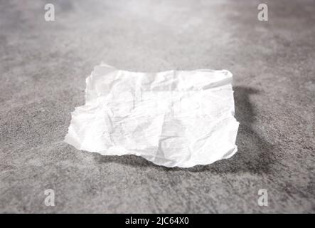 White baking empty paper piece on grey stone table. Food advertisement design element.Kitchen dish with empty space. Stockfoto