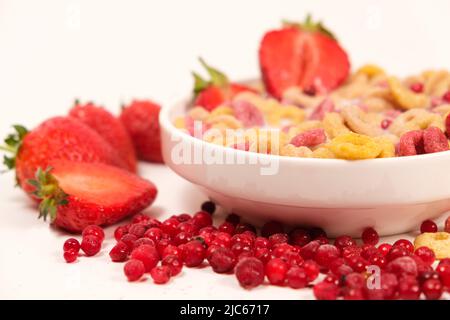 Schnelles Frühstück mit Getreide und Maiskörnern und Weizenringen mit Erdbeeren und Preiselbeeren. Stockfoto