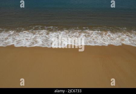 Ruhige Meereswellen am tropischen Sandstrand, sanfte, wunderschöne Meereswelle am Sandstrand. Stockfoto