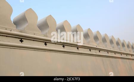 Uralte weiße Betonmauer kontrastiert mit blauem Himmel Stockfoto