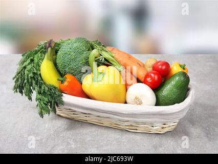 Frisches Obst und Gemüse im Korb auf dem Tisch. Lieferung von Bio-Lebensmitteln. Vegetarische Produkte. Vitamindiät. Gesundes Ernährungskonzept. Stockfoto