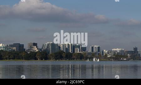 Schimmernde Oberfläche des Albert Park im Winter, voller Vogelwelt, mit den Wolkenkratzern von Queens Rd und St Kilda Rd im Hintergrund Stockfoto