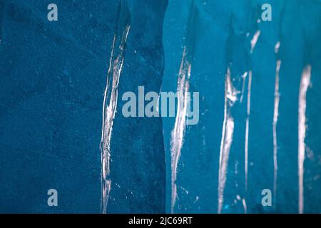 Hintergrund mit blauer Eisstruktur. Oberfläche des Eisblocks mit Lichtreflexionen. Stockfoto