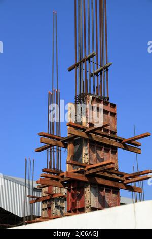 Betonpolbau eines neuen Gebäudes. Baustelle. Eiserne Struktur bereit, mit Beton gegossen werden. Stahlschalung für Betonstangen. Stockfoto