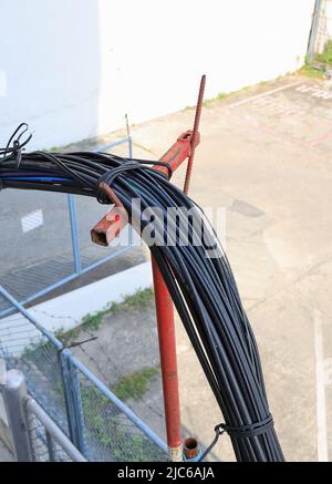 Haufen von Elektrik- und Kommunikationsdrähten, Drähte auf dem Mast, das Chaos von Kabeln und Drähten auf einem elektrischen Mast. Stockfoto