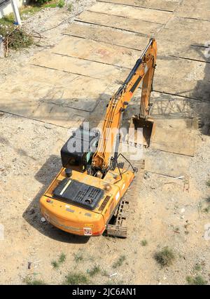 Bagger mit hydraulischem Hammer oder Bagger zur Zerstörung von Beton- und Hartsteinarbeiten auf der Baustelle. Stockfoto