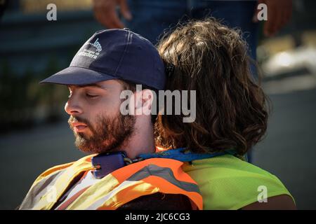 CARRARA, ITALIEN. 10/06/2022. Während eines Protestes gegen die Marmorsteinbrüche sperren sich die Protestierenden „Extinction Rebellion“ und „Last Generation“ zusammen und blockieren die Straße aus Marmor in Carrara. Die Marmorbrüche in den Apuanischen Alpen gelten von italienischen Umweltschützern als Europas größte Umweltkatastrophe. Quelle: Misanthropicture - Manuel Micheli/Alamy Live News Stockfoto