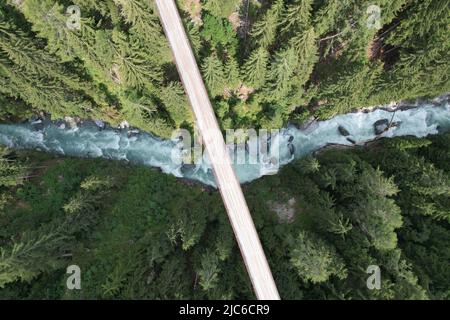 Drone aus der Vogelperspektive auf einer Hängebrücke und einem Flusstal im Schweizer Alpenwald, Schweiz Stockfoto