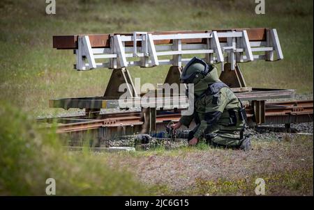 Ravlunda, Schweden. 10.. Juni 2022. RAVLUNDA 2022-06-10Personnel in Bombenschutzanzug des norwegischen Minedykker Kommandos, als bei der Pressemonstration am Freitag beim Baltops-Training auf dem Schießplatz Ravlunda an der Ostküste von Skåne mit Hilfe von Bombenrobotern und Wasserladungen eine Granate auf Eisenbahnschienen im Trainingsgelände entwaffnet wird. In den nächsten Tagen werden sich 250 Teilnehmer aus acht Ländern in Ravlunda versammeln, um die Minenräumung, die Erkennung und Abrüstung von Bomben und Sprengstoffen zu üben. Etwa 30 Übungsminen wurden außerhalb des Schießbereichs im Meer aufgestellt. T Stockfoto