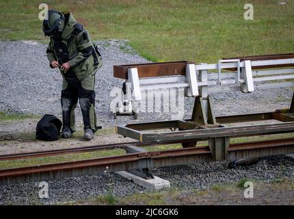 Ravlunda, Schweden. 10.. Juni 2022. RAVLUNDA 2022-06-10Personnel in Bombenschutzanzug des norwegischen Minedykker Kommandos, als bei der Pressemonstration am Freitag beim Baltops-Training auf dem Schießplatz Ravlunda an der Ostküste von Skåne mit Hilfe von Bombenrobotern und Wasserladungen eine Granate auf Eisenbahnschienen im Trainingsgelände entwaffnet wird. In den nächsten Tagen werden sich 250 Teilnehmer aus acht Ländern in Ravlunda versammeln, um die Minenräumung, die Erkennung und Abrüstung von Bomben und Sprengstoffen zu üben. Etwa 30 Übungsminen wurden außerhalb des Schießbereichs im Meer aufgestellt. T Stockfoto