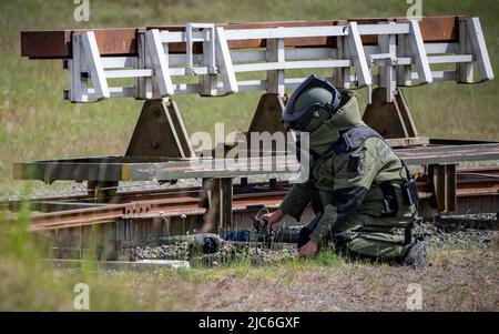 Ravlunda, Schweden. 10.. Juni 2022. RAVLUNDA 2022-06-10Personnel in Bombenschutzanzug des norwegischen Minedykker Kommandos, als bei der Pressemonstration am Freitag beim Baltops-Training auf dem Schießplatz Ravlunda an der Ostküste von Skåne mit Hilfe von Bombenrobotern und Wasserladungen eine Granate auf Eisenbahnschienen im Trainingsgelände entwaffnet wird. In den nächsten Tagen werden sich 250 Teilnehmer aus acht Ländern in Ravlunda versammeln, um die Minenräumung, die Erkennung und Abrüstung von Bomben und Sprengstoffen zu üben. Etwa 30 Übungsminen wurden außerhalb des Schießbereichs im Meer aufgestellt. T Stockfoto