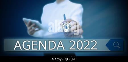 Textschild mit Agenda 2022. Internet-Konzept Liste der Aktivitäten, um die sie aufgenommen werden Geschäftsmann in Anzug mit offenen Palmen Stockfoto