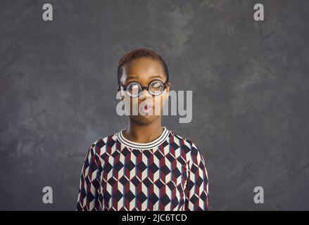 Lustige gen z ethnische Frau in Brille auf Studio Hintergrund Stockfoto