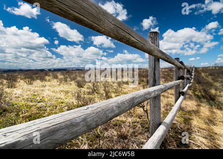 Ein hölzerner Pfosten- und Eisenbahnzaun auf natürlichem Grasland auf den kanadischen Prärien im Glenbow Ranch Provincial Park Alberta Stockfoto