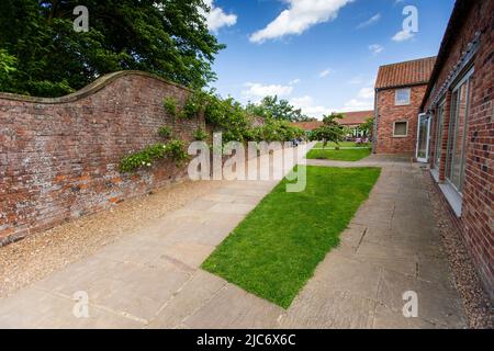 Doddington Hall ist von außen ein elisabethisches Wunderhaus oder Herrenhaus mit ummauerten Innenhöfen und einem Giebelhaus. Im Inneren wurde es im Jahr 1760s weitgehend aktualisiert. Es befindet sich im Dorf Doddington, westlich der Stadt Lincoln in Lincolnshire, England. Die Halle und die Gärten sind für die Öffentlichkeit zugänglich und bieten Einrichtungen für private Führungen und Schulbesuche. In den Gärten steht ein von Anthony Jarvis 1973 entworfener Tempel.in der Long Gallery finden Sommerkonzerte und gelegentliche Ausstellungen statt. Auf dem Anwesen wurden weitere Geschäfte entwickelt. Stockfoto