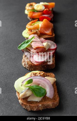 Dänische Küche. Sauerteig mit Hering und Zwiebeln. Smorrebrod – traditionelle dänische offene Sanwisches. Stockfoto