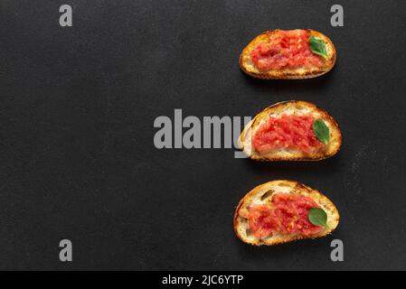 Spanischer Tomatensoast, traditionelles Frühstück oder Mittagessen. Spanischer Toast auf dunklem Hintergrund von oben. Speicherplatz kopieren. Stockfoto