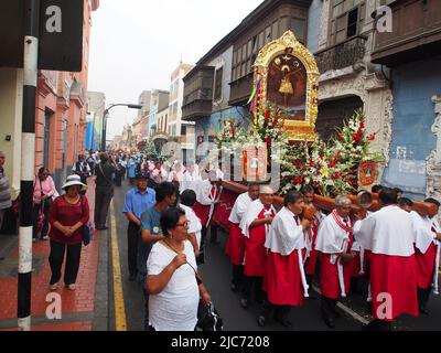 Devatees of Lord of Qoyllur Riti, die einen religiösen Wurf tragen. Hunderte von Menschen begleiteten die Bilder des quechua-sprechenden Pfarrhauses von San Sebastian und Monserrate, die in einer Prozession die Stadt Lima zum 482. Jahrestag ihrer Gründung begrüßten. Stockfoto