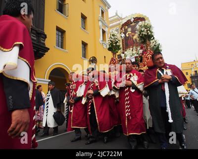 Devatees of Lord of Qoyllur Riti, die einen religiösen Wurf tragen. Hunderte von Menschen begleiteten die Bilder des quechua-sprechenden Pfarrhauses von San Sebastian und Monserrate, die in einer Prozession die Stadt Lima zum 482. Jahrestag ihrer Gründung begrüßten. Stockfoto