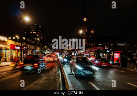 Nachtverkehr entlang der Euston Road vor dem Bahnhof Kings Cross, London - Nachtaufnahme, Langzeitbelichtung. Stockfoto