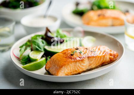 Gegrilltes Lachsfilet und frischer Gemüsesalat. Mediterrane Ernährung. Stockfoto