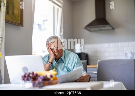 Ein älterer Mann, der seine Finanzprobleme durchläuft Stockfoto